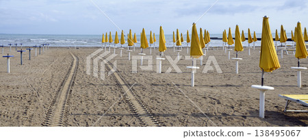 beach with closed yellow sun umbrellas beach with closed yellow sun umbrellas 138495067