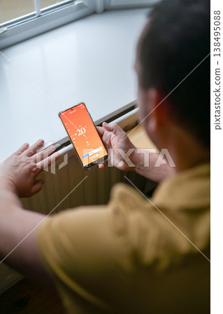 Smartphone connecting to heating system. Remote home control system on a smartphone. smart home Smartphone connecting to heating system. Remote home control system on a smartphone. smart home 138495088