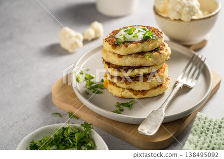Vegetarian cauliflower pancakes, fritters served with sour cream Vegetarian cauliflower pancakes, fritters served with sour cream 138495092