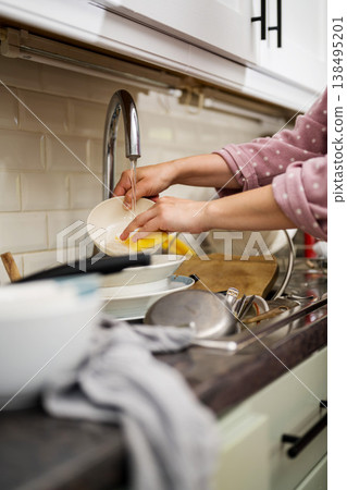 Woman washing dishes in kitchen, the mindful chore Woman washing dishes in kitchen, the mindful chore 138495201