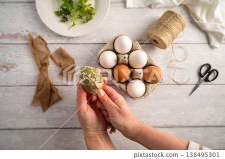 DIY Easter eggs with natural leaves, creating patterns on eggs using plants. Eco friendly colouring easter eggs DIY Easter eggs with natural leaves, creating patterns on eggs using plants. Eco friendly colouring easter eggs 138495301