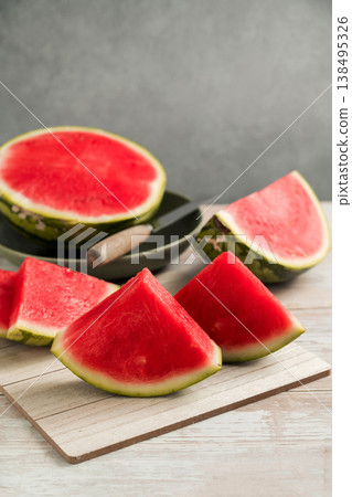 Slices of fresh watermelon on bright rustic wooden table Slices of fresh watermelon on bright rustic wooden table 138495326