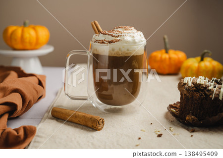 Pumpkin spice latte in glass mug with whipped cream and spices, autumn hot drink 138495409