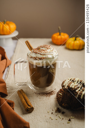 Pumpkin spice latte in glass mug with whipped cream and spices, autumn hot drink Pumpkin spice latte in glass mug with whipped cream and spices, autumn hot drink 138495426