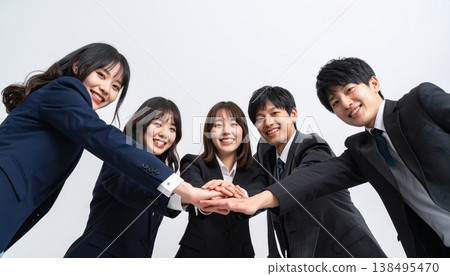 由五名身著西裝的男女組成的商務團隊，手牽手，團結一致。 138495470
