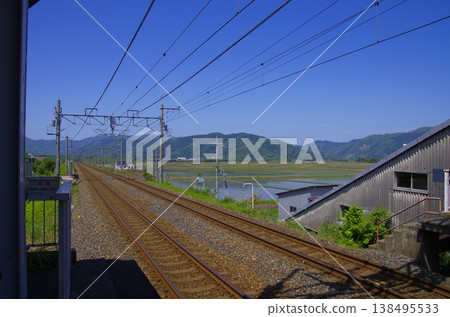 A railway track stretching under a blue sky and a quiet station platform (Takashima City, Shiga Prefecture) 138495533