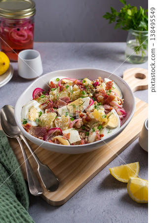 Egg potato salad with bacon and fresh herbs in a plate 138495549