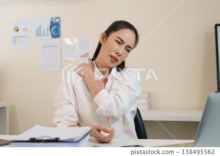 Office worker experiencing neck and back pain from prolonged computer work Office worker experiencing neck and back pain from prolonged computer work 138495562