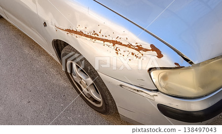 Scratched Gray Car with Rust Damage on Side Panel Scratched Gray Car with Rust Damage on Side Panel 138497043