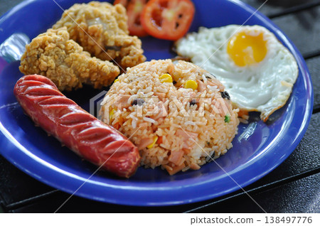 stir fried rice or fried rice with sunny side up egg , fried chicken and sausage stir fried rice or fried rice with sunny side up egg , fried chicken and sausage 138497776