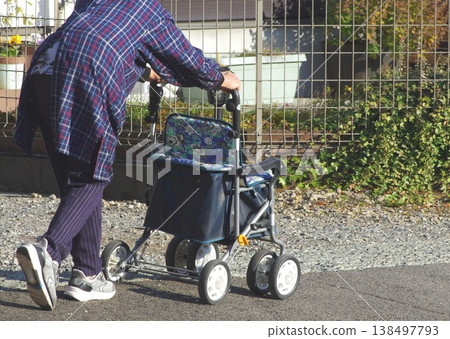 一位老婦人拄著助行器外出。 138497793