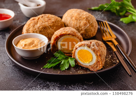 Traditional Scotch Eggs on a black plate. Traditional Scotch Eggs on a black plate. 138498276
