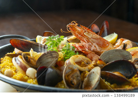 海鮮飯:奢華的西班牙菜餚,盛放在海鮮飯鍋中,裡面滿滿都是蝦子、貽貝、蛤蜊和魷魚。 海鮮飯:奢華的西班牙菜餚,盛放在海鮮飯鍋中,裡面滿滿都是蝦子、貽貝、蛤蜊和魷魚。 138499189