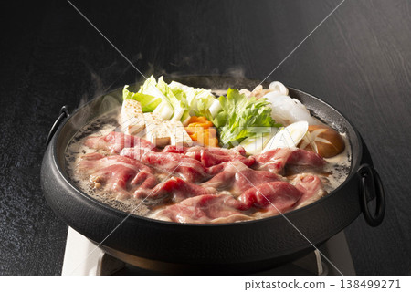 Beef Sukiyaki in a Black Iron Pot: Tofu, Chinese Cabbage, Green Onions, and Egg. A hearty winter hot pot dish with steaming hot pot, featuring luxurious Wagyu beef. Beef Sukiyaki in a Black Iron Pot: Tofu, Chinese Cabbage, Green Onions, and Egg. A hearty winter hot pot dish with steaming hot pot, featuring luxurious Wagyu beef. 138499271