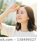 A young woman looks up at the sunlight, embodying summer sun protection and a refreshing beauty image. 138499327