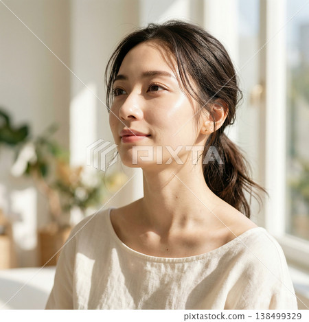 A woman's profile bathed in natural light, showcasing her natural, beautiful skin and relaxed image. 138499329