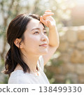 A young woman looks up at the sunlight, embodying summer sun protection and a refreshing beauty image. 138499330