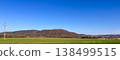 Rural landscape with green field hills and blue sky in countryside panorama with spring meadow nature view 138499515