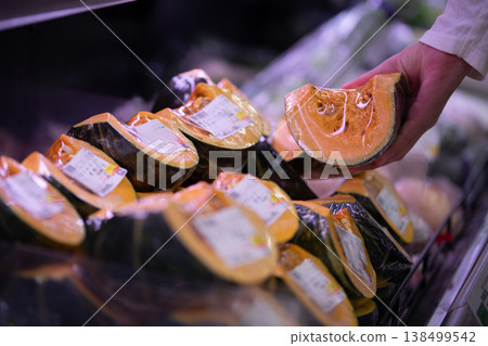 Hands of shoppers choosing cut pumpkins Hands of shoppers choosing cut pumpkins 138499542