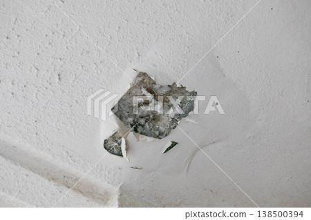 Paint peeling and signs of spalling on a concrete wall 138500394
