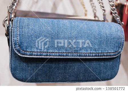 Stylish denim crossbody bag hanging in a boutique showcasing modern fashion accessories 138501772