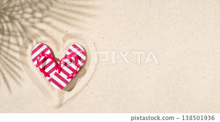 Colorful striped flip flops arranged in heart shape on sandy beach with palm shadow Colorful striped flip flops arranged in heart shape on sandy beach with palm shadow 138501936