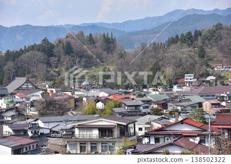 The beautiful townscape of Takayama City, Gifu Prefecture, Japan, and the surrounding mountains; cherry blossoms in spring bud and a mix of old and new houses; a view from Shiroyama Park. The beautiful townscape of Takayama City, Gifu Prefecture, Japan, and the surrounding mountains; cherry blossoms in spring bud and a mix of old and new houses; a view from Shiroyama Park. 138502322