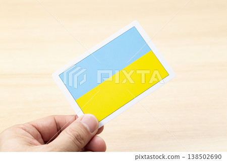 A hand holding a Ukrainian flag card A hand holding a Ukrainian flag card 138502690
