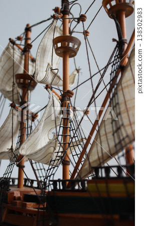 The deck of a three-masted pirate ship with sails and rigging. Deck ropes and sail ropes on the masts of an old sailing ship. Sails and rigging of a sailing vessel 138502983