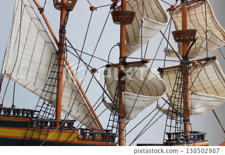 Historic Ship Figurine Rigging Details. Sails and Masts of Wooden Frigate Model Closeup View. Sails unfurled on different masts of an old frigate model 138502987