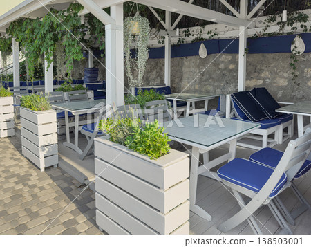 Outdoor dining setup with plants and seating areas 138503001