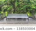 White bench under green leaves in a park area 138503004