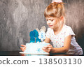 The child blows out the candles on the cake.  138503130