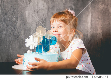 The child blows out the candles on the cake 138503151