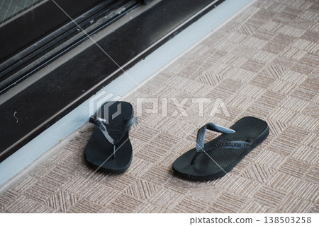 Black sandals placed at the entrance to the balcony Black sandals placed at the entrance to the balcony 138503258