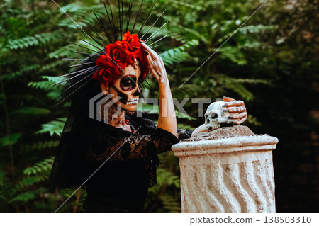Day of the Dead. Portrait of a woman with a wreath of red roses and a skull on a column. Artistic composition Day of the Dead. Portrait of a woman with a wreath of red roses and a skull on a column. Artistic composition 138503310