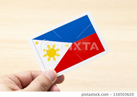 A hand holding a Philippine flag card A hand holding a Philippine flag card 138503620