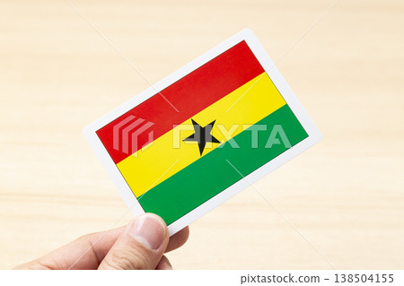 A hand holding a Ghana flag card A hand holding a Ghana flag card 138504155