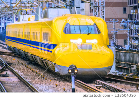 A rare sight in the urban landscape of Yokohama, Japan... The Doctor Yellow train arriving at Shin-Yokohama Station. As it enters the straight track, its beautiful form can be seen in its entirety. 138504350