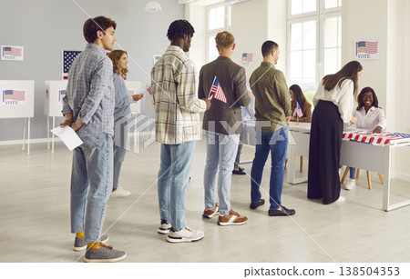 Large diverse group of people registering at polling station holding American flags on election day 138504353