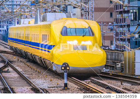 在日本橫濱的城市景觀中,這是一道難得一見的景象…「醫生黃號」列車抵達新橫濱站。當它駛入筆直的軌道時,其優美的身姿得以完整展現。 在日本橫濱的城市景觀中,這是一道難得一見的景象…「醫生黃號」列車抵達新橫濱站。當它駛入筆直的軌道時,其優美的身姿得以完整展現。 138504359