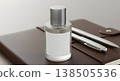Perfume Bottle On A Leather Journal Beside Silver Pens With A Blurred Background 138505536