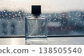 Perfume Bottle Standing on Wet Surface with Raindrops and Blurred Background 138505540
