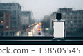 Perfume Bottle With Blank Label On Windowsill Against Blurred Rainy Cityscape 138505545