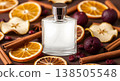 Perfume Bottle with Dried Orange Slices Cinnamon Sticks and Cranberries on Brown Surface with Warm Lighting 138505548
