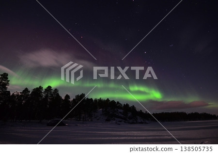 In Inari, in the Finnish Lapland region, a fantastical green aurora appeared above a snow-covered cottage. In Inari, in the Finnish Lapland region, a fantastical green aurora appeared above a snow-covered cottage. 138505735