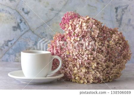White cup of coffee or tea and pink hydrangea flower on a gray marble background 138506089