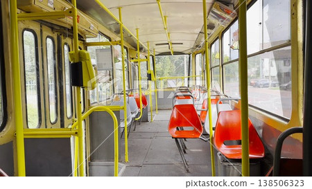 Empty tram moves along city street at sunny summer day. The calm street and passing tram capture urban life and modern public transportation in motion, emphasizing rhythm, movement and city flow Empty tram moves along city street at sunny summer day. The calm street and passing tram capture urban life and modern public transportation in motion, emphasizing rhythm, movement and city flow 138506323