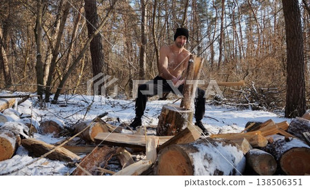 Shirtless strong man chopping firewood in a sunny winter forest. Muscular guy working with axe in snowy woodland. Concept of strength, masculine, energy and harmony with nature during cold season Shirtless strong man chopping firewood in a sunny winter forest. Muscular guy working with axe in snowy woodland. Concept of strength, masculine, energy and harmony with nature during cold season 138506351