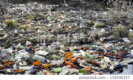 Dirty river is polluted with many plastic bottles. A lot of trash is dumped in open and freely available places at nature. Global environmental pollution problem. Concept of ecological disaster 138506357